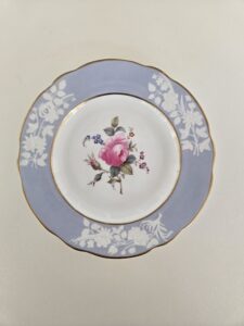 Dessert plate with a blue rim and floral designs.