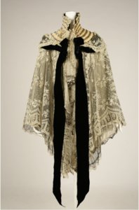 A high neck collar off white lace wrap with a black neck tie that hangs in the front