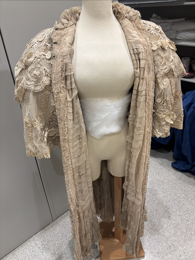 The front of the Madeleine Laferriere Cloak, it opens in the center and mirrors design on left and right side with lace ruffled quarter length sleeves, lace along the center