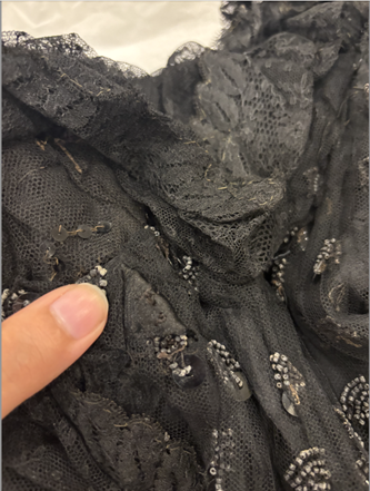 Up close of beadwork, showing where the original neckline could have been by the ruffles