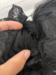 Close up of the possible original neckline where corded detailing is. See bunched up fabric and some pulling.